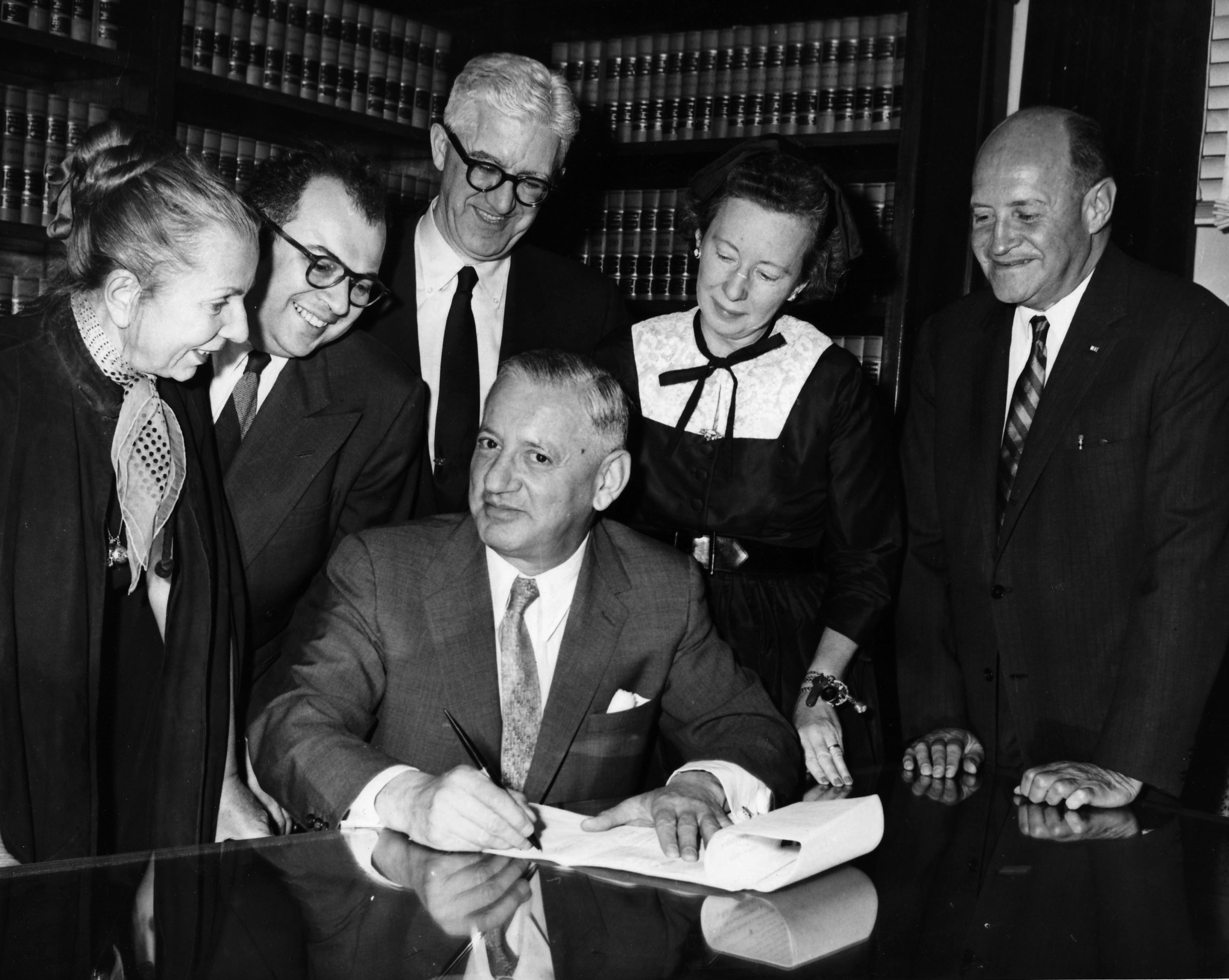 Judge Saul Streit, Presiding Justice of the New York Supreme Court (seated), signs the incorporation documents witnessed by original Members (left to right) Hanya Holm, Ezra Stone, Shepard Traube, Agnes de Mille + legal counsel Erwin Feldman.